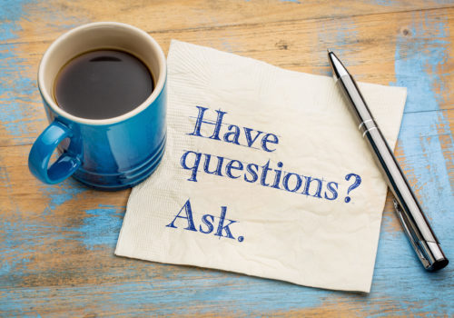 Have questions? Ask. Handwriting on a napkin with a cup of espresso coffee